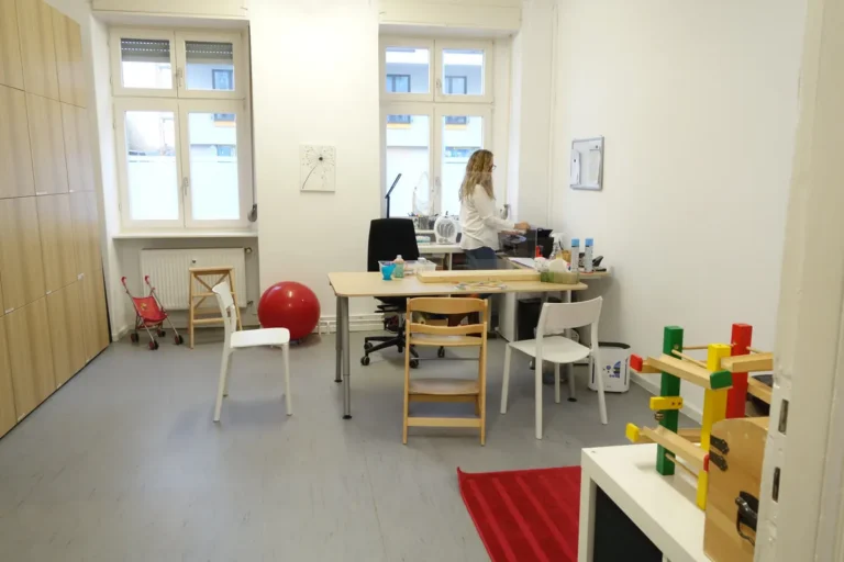 Heller Therapieraum mit Schreibtisch, Kindertisch und Spielmaterial in der Dennewitzstraße