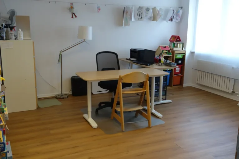 Therapieraum mit Schreibtisch, Stehlampe und Spielhaus