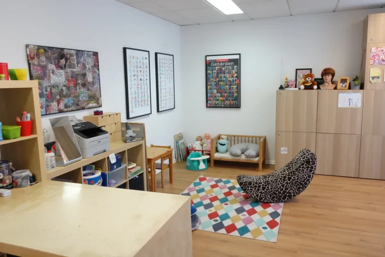 Heller Therapieraum mit Spielecke, Teppich und Kindermöbeln